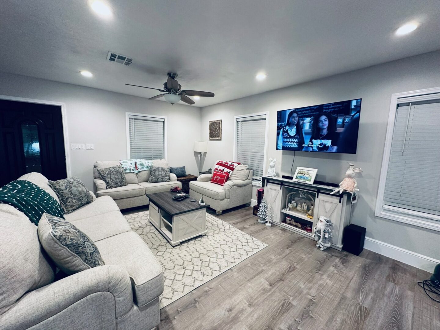 Cozy modern living room with gray sofas and a wall-mounted TV.