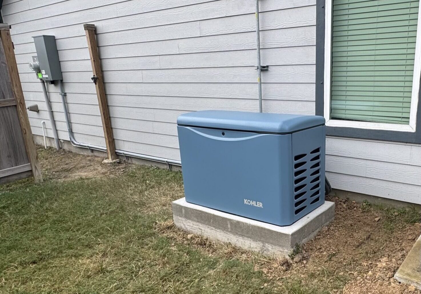 Kohler residential standby generator installed on a concrete pad beside a home by The Shock Doc Electrical Services in League City Tx